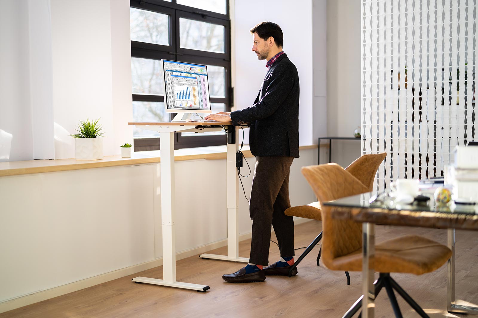 man standing at desk with computer